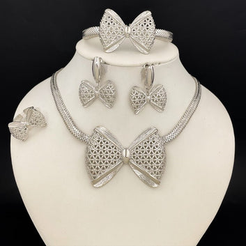 Silver bow-shaped jewelry set on a mannequin bust against a black background