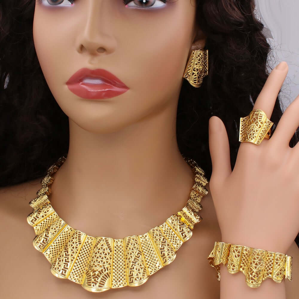 Mannequin wearing gold jewelry including a necklace, earrings, ring, and bracelet.