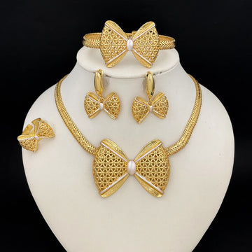 Gold jewelry set including necklace, earrings, and bracelet on a white stand with a black background