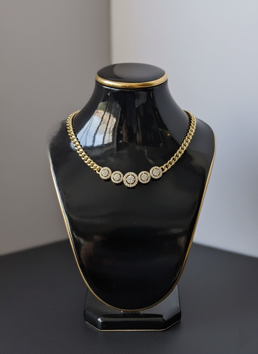 Black mannequin bust with gold and diamond necklace on a gray background