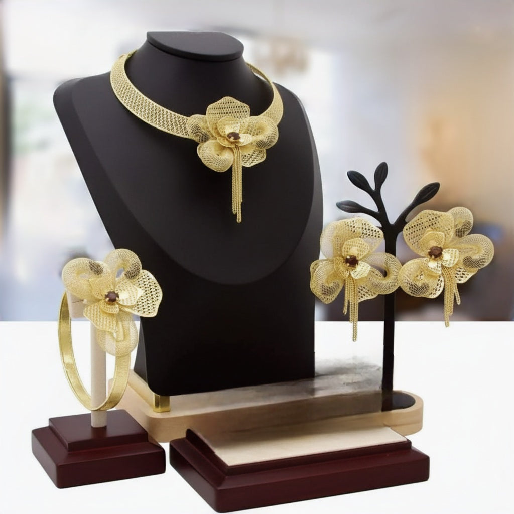 Gold floral jewelry set on a black mannequin and wooden display stand.
