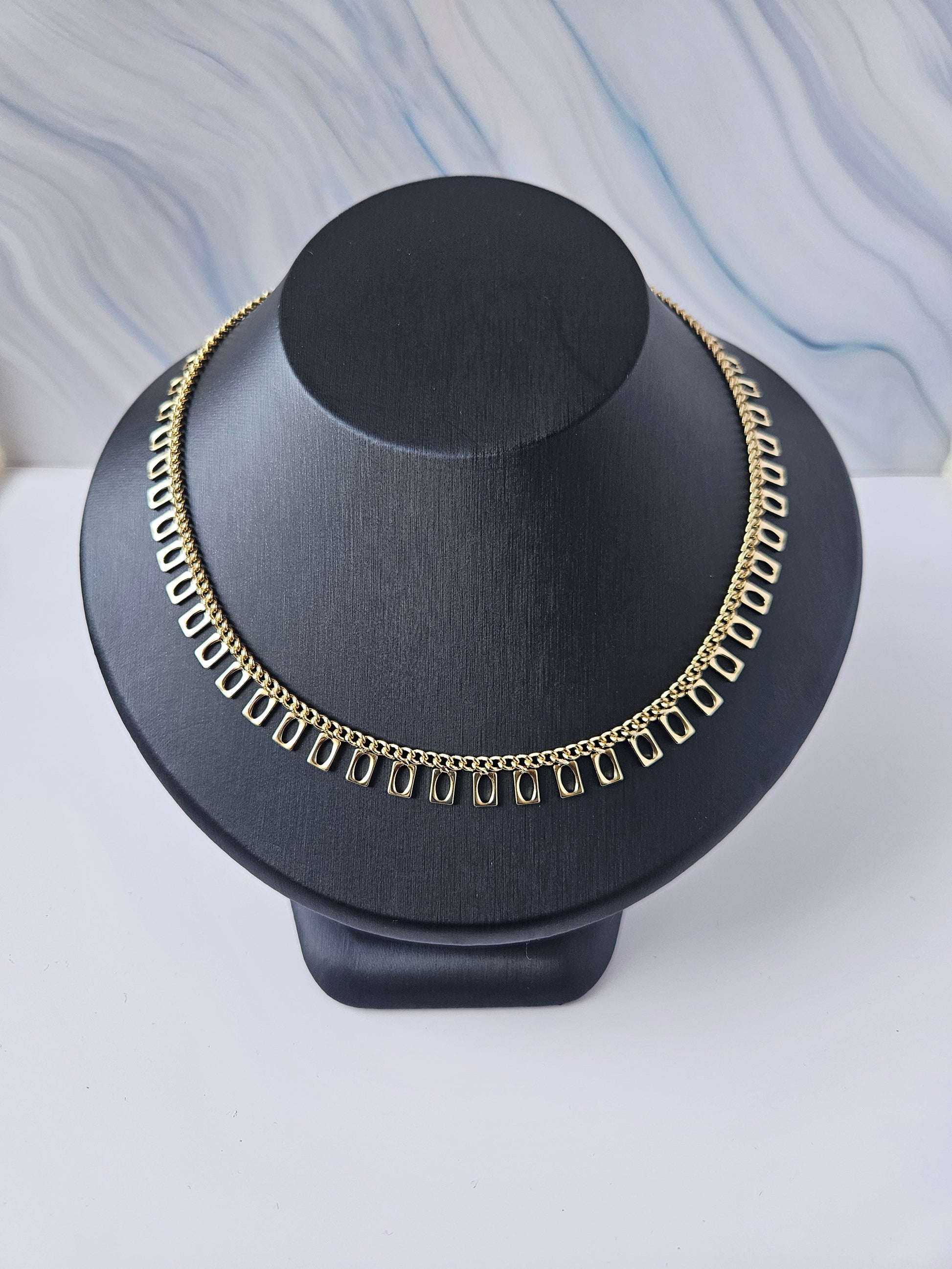 Decorative wall-mounted fixture with black and gold design on a light gray background