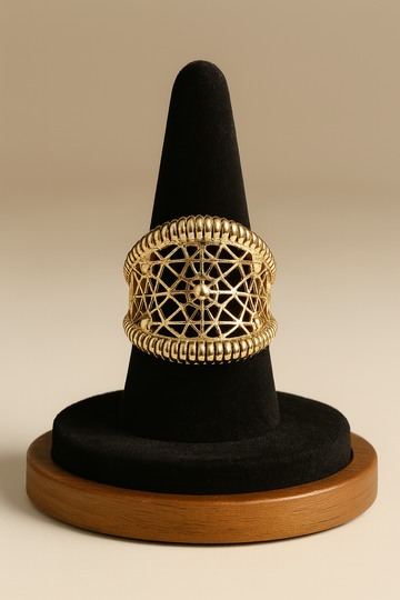 Gold ring on a black cone-shaped stand with a beige background