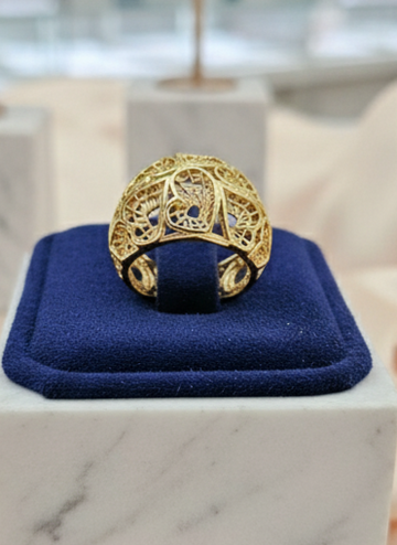 Gold ring on a blue cushion in a jewelry store setting