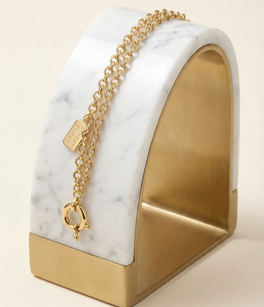 Gold bracelet with a marble base on a beige background