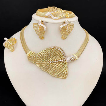 Gold jewelry set including necklace, earrings, and bracelet on a white stand with a black background.