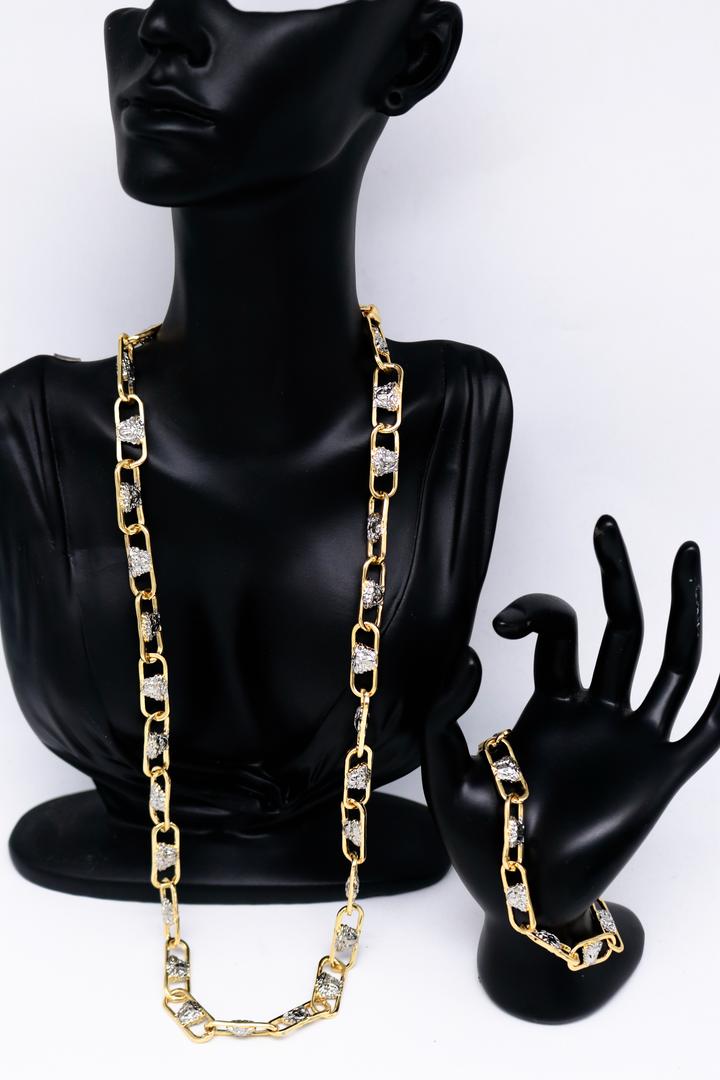 Gold chain necklace displayed on a black mannequin with a white background