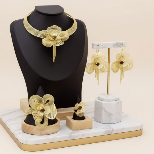 Gold jewelry set including necklace, earrings, and pendants on a decorative stand.