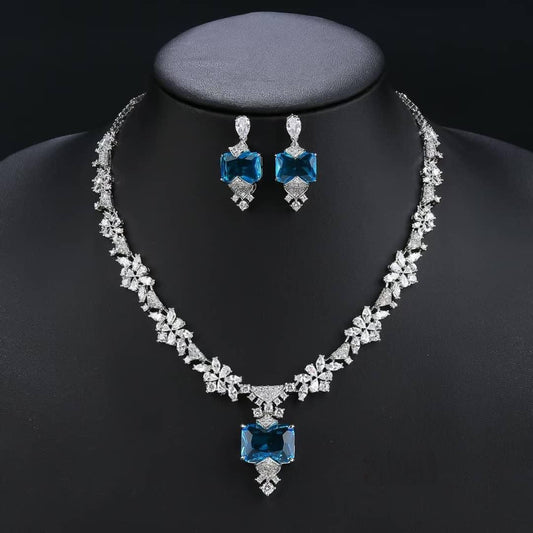 Jewelry set with necklace and earrings featuring blue gemstones on a black background