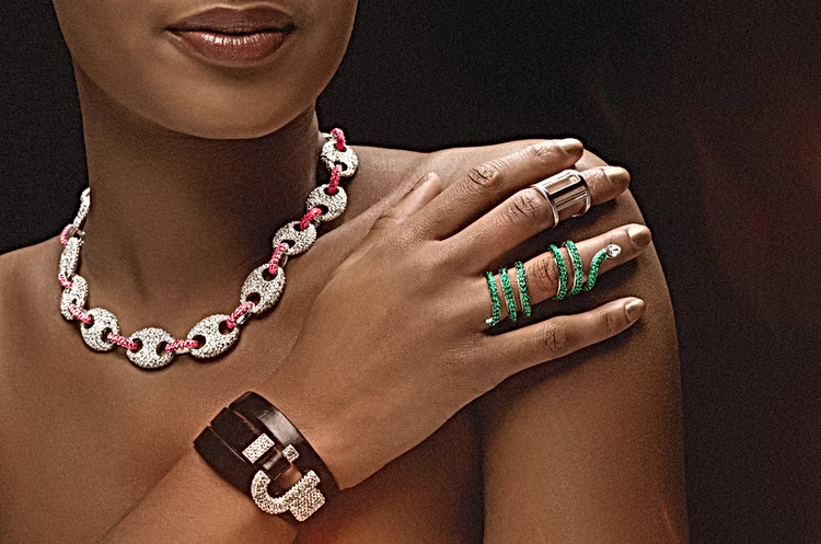Jewelry set including a necklace, rings, and bracelet on a model against a dark background