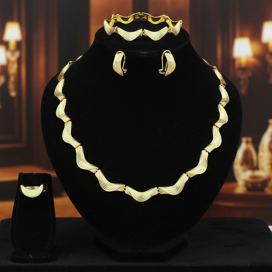 Gold necklace and earrings on a black stand with a blurred background