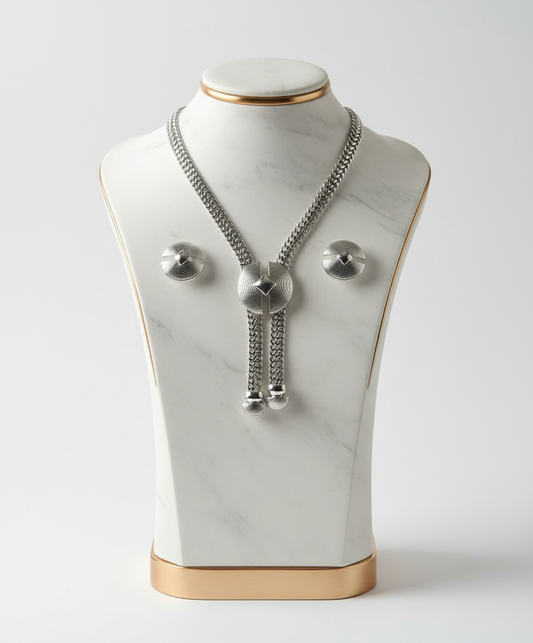 Silver necklace on a marble bust with gold base against a white background