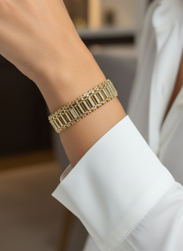 Gold bracelet on a person's wrist with a blurred indoor background