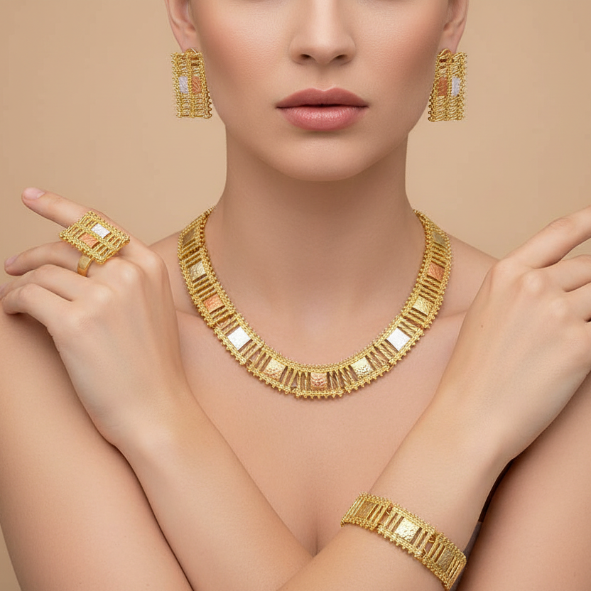 Woman wearing gold jewelry including necklace, earrings, and bracelet on a beige background