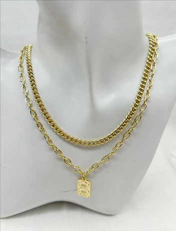 Gold chain necklace with a tag on a mannequin bust.