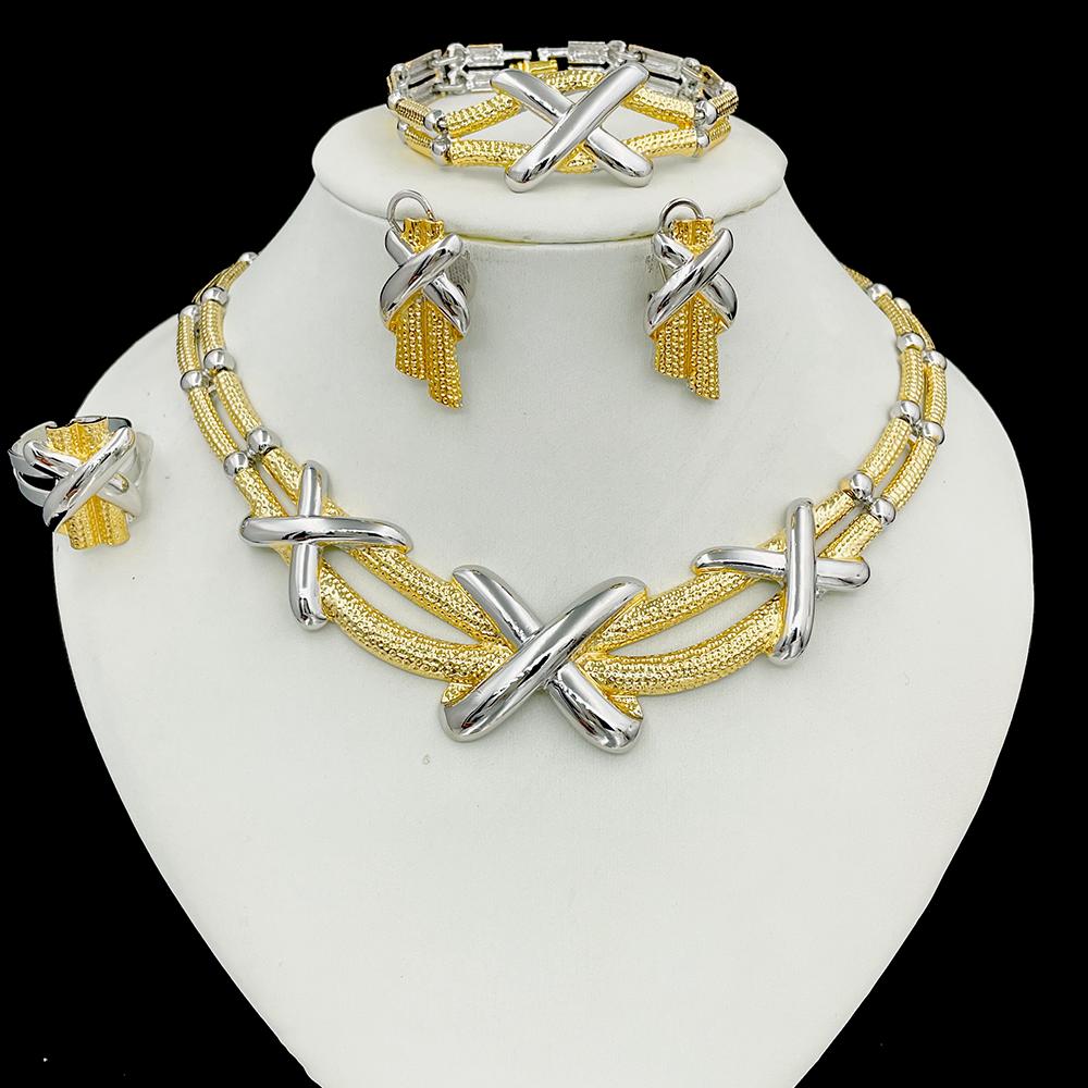 Jewelry set with gold and silver necklaces, bracelets, and earrings on a white stand.