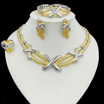 Jewelry set with gold and silver necklaces, bracelets, and earrings on a white stand.