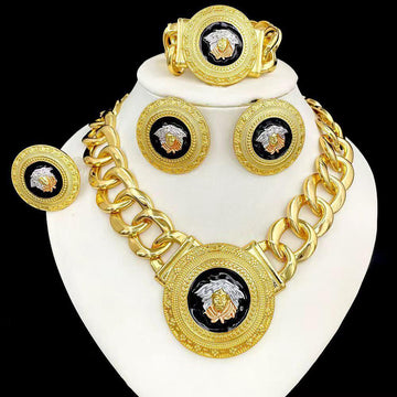 Gold necklace, bracelet, and earrings set on a white stand with a black background