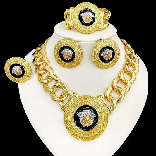 Gold necklace, bracelet, and earrings set on a white stand with a black background