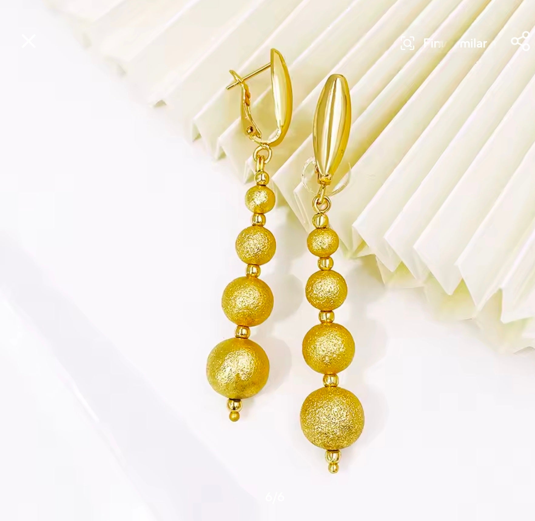 Gold beaded earrings on a white background
