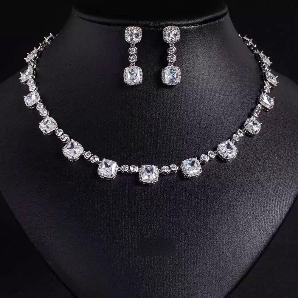 Silver necklace and earrings set on a black mannequin
