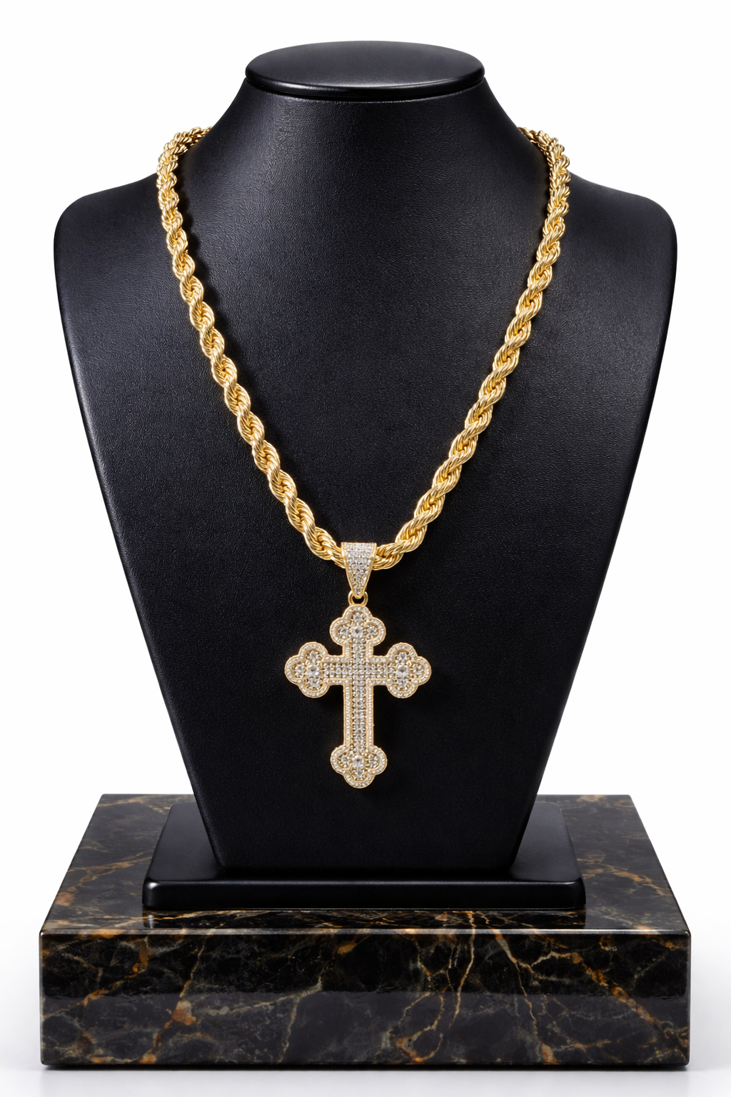 Gold chain necklace with a cross pendant on a black marble stand