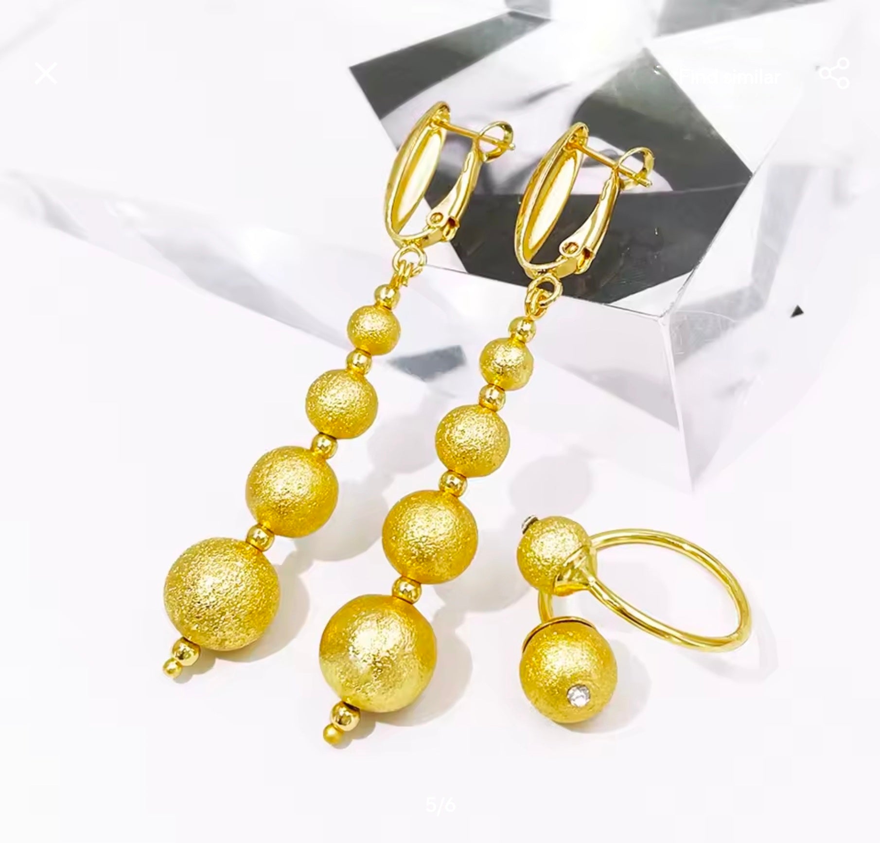 Gold beaded earrings on a white background