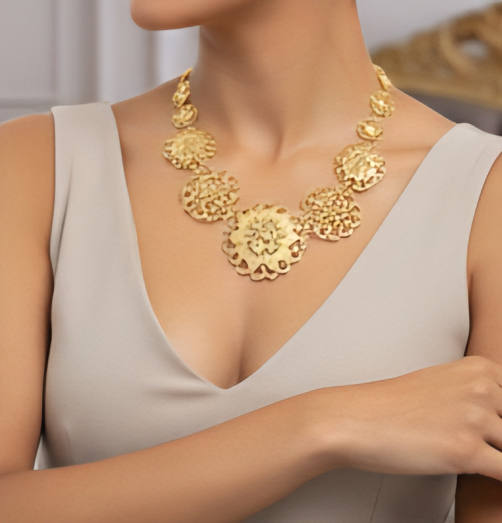 Gold necklace worn by a model against a neutral background