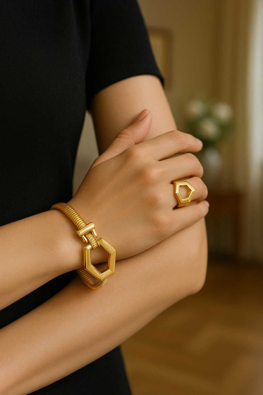 Adesewa Gold jewelry set on a woman's wrist with a blurred indoor background