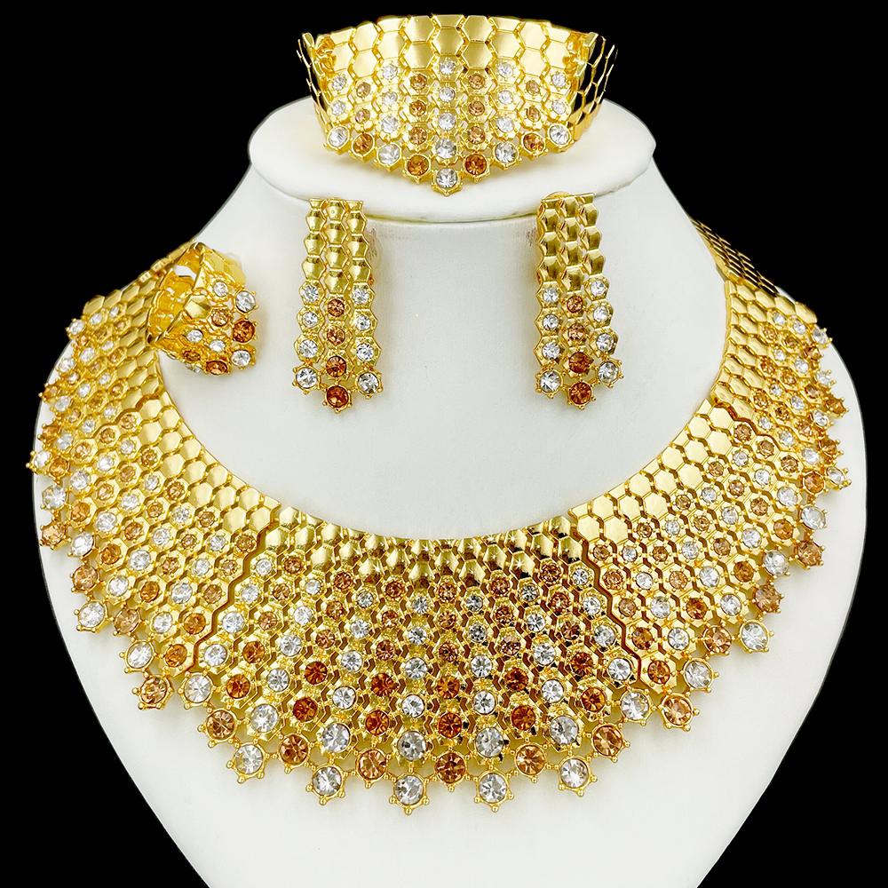 Gold jewelry set including necklace, earrings, and bracelet on a white stand.