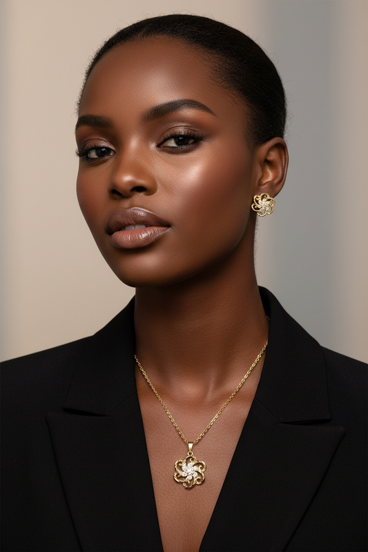 Woman wearing a black blazer and gold jewelry against a neutral background