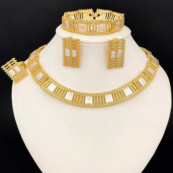 Gold jewelry set including necklace, earrings, and bracelet on a white stand with a black background.