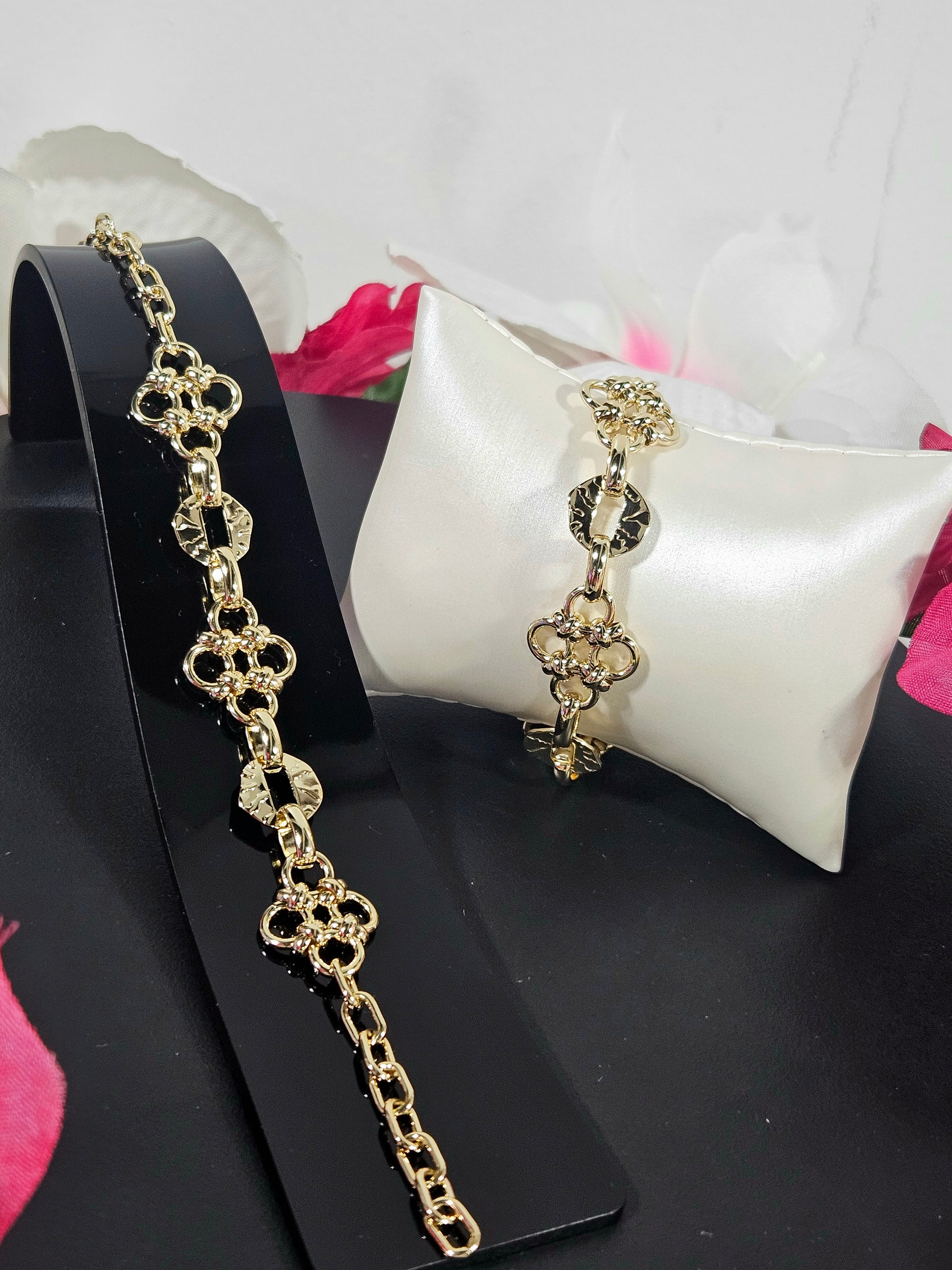 Gold chain earring on a black stand with a white cushion