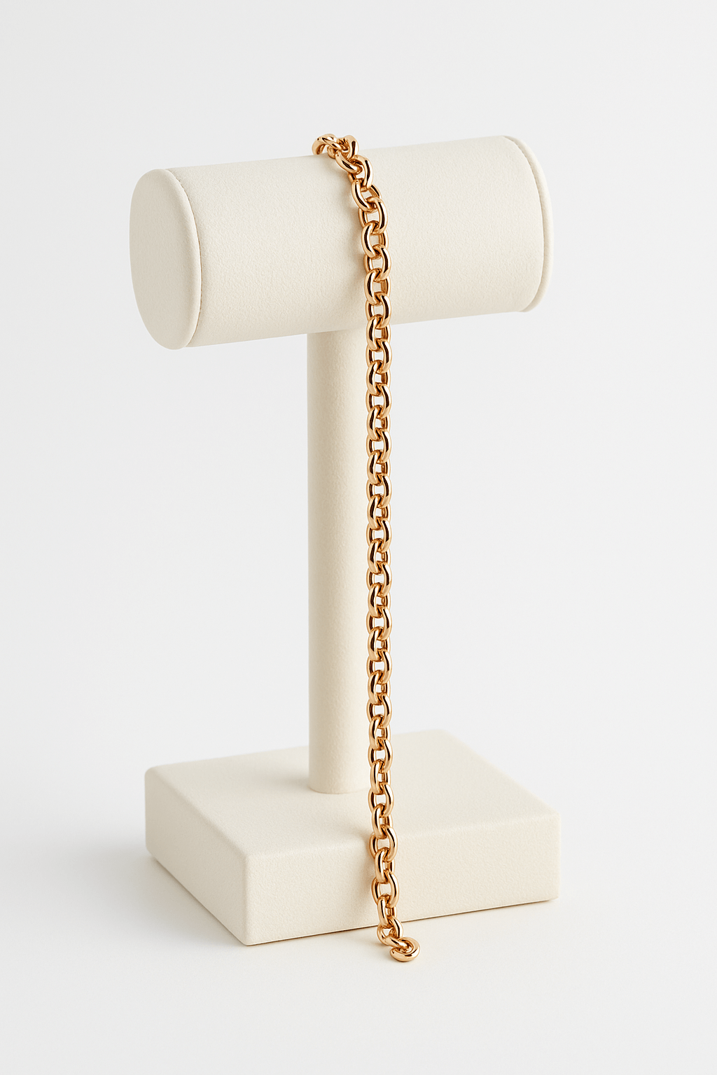 Gold chain on a white jewelry stand against a white background