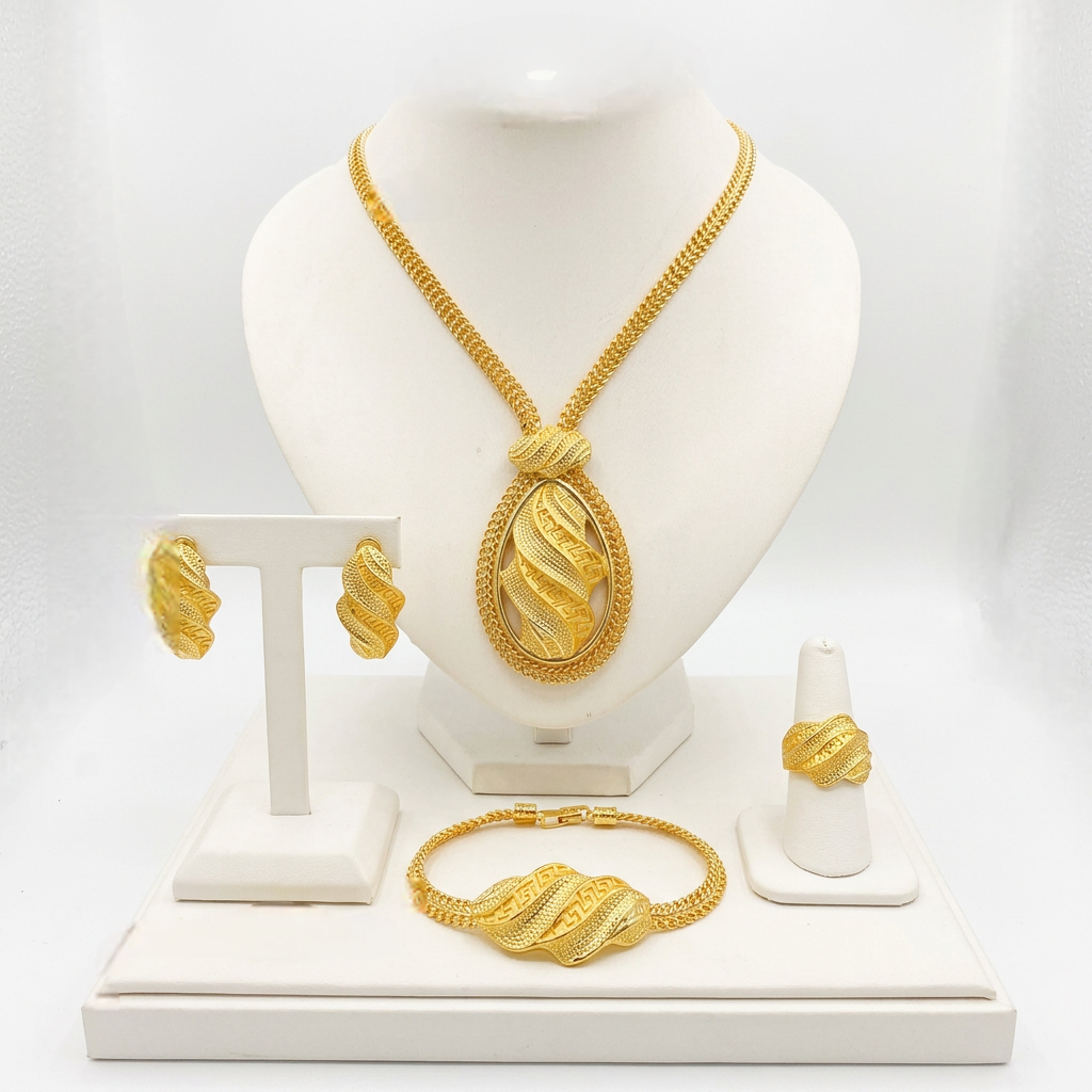 Gold jewelry set including necklace, bracelet, and ring on a white stand.