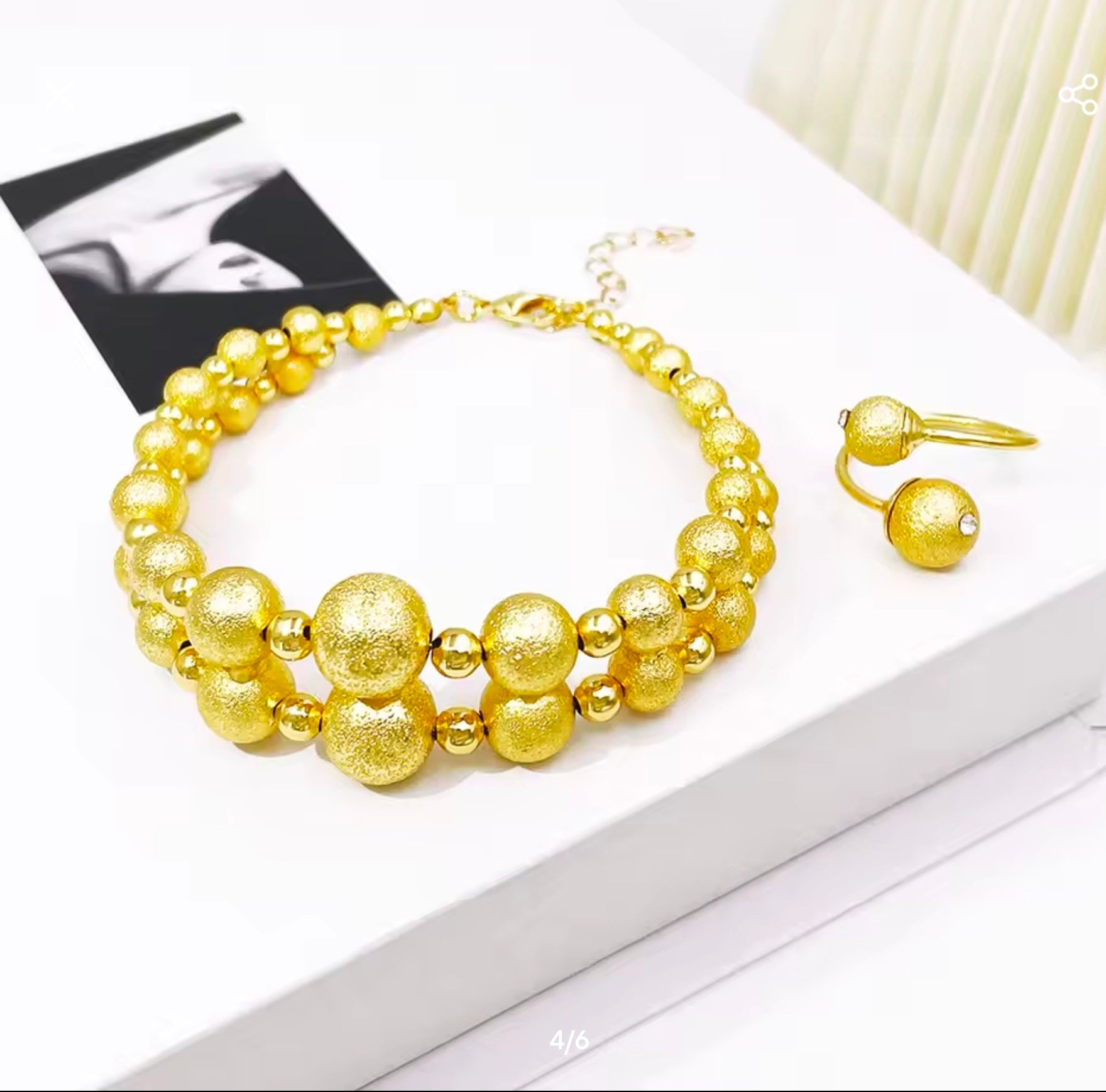 Gold necklace and earrings on a white surface